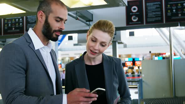 Business people discussing over smartphone