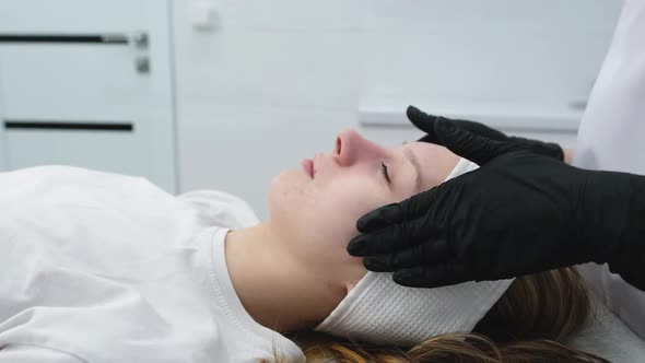 Cosmetologist Applies a Woman a Therapeutic Mask on Her Face