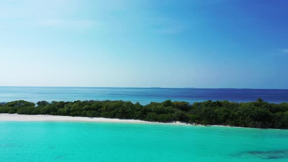 Aerial flying over sky of perfect shore beach lifestyle by shallow ocean and white sandy background 