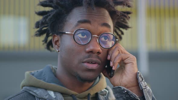 Headshot of Young Handsome African American Man Talking on the Phone Outdoors on Urban City Street