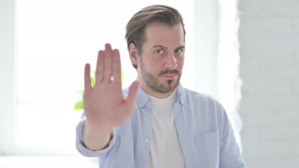 Portrait of Rejecting Young Man Showing Stop Sign