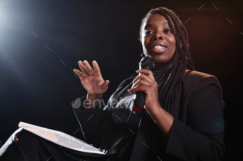 Black Woman Speaking to Mic on Stage