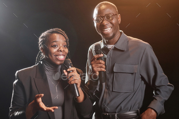 Black couple on stage speaking to microphone