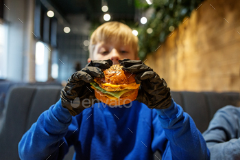 Child Enjoying Gourmet Burger in Restaurant