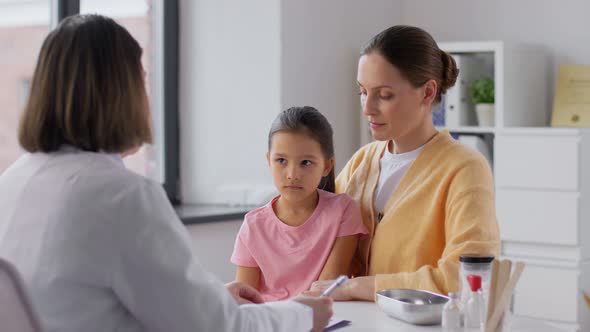 Mother with Little Daughter and Doctor at Clinic