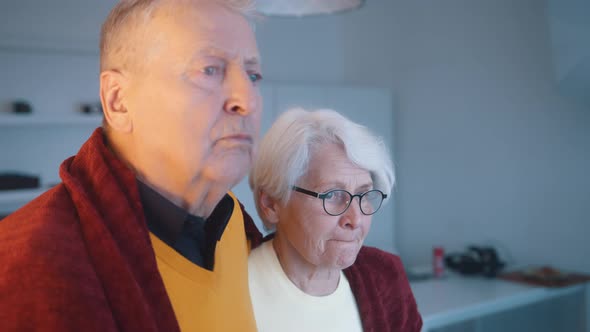 Elderly Couple Looking Through the Window with Flashing Police Lights