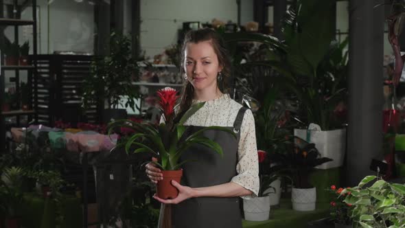 Girl Florist with a Flower in Her Hands Looks at the Camera