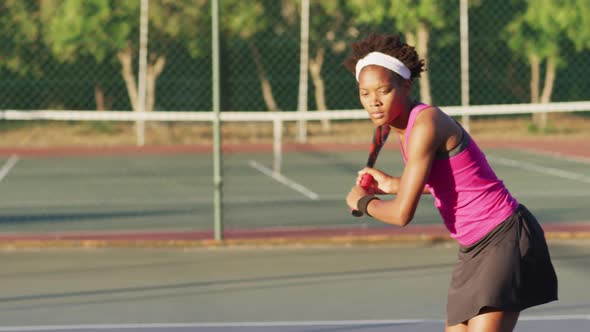 Video of focused african american female tennis player holding racket and hitting ball