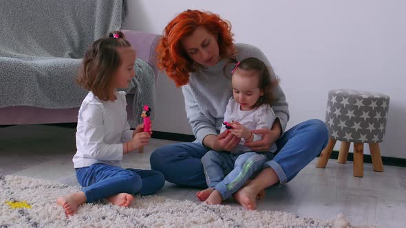 A young redhead mother playing with her two daughters in the house