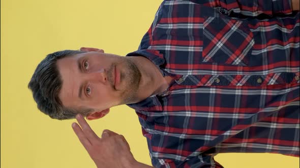 Portrait of Bored Young Man Shooting Herself in the Head with Finger Gun Gesture.