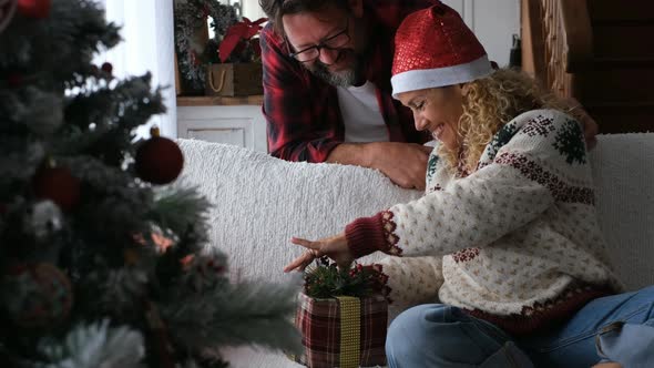 Happy woman opening Christmas gift of husband