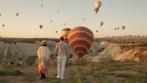 Man and Woman Looking at Hot Air Balloons, Couple in love among balloons