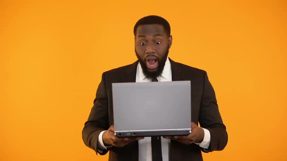 Surprised African-American Male Reading News on Laptop, Career Promotion, Winner