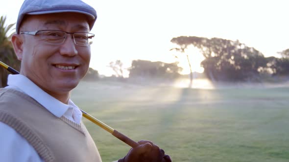 Golfer carrying golf club over shoulder while standing on the golf course