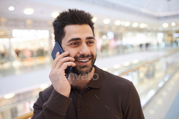 Man speaking on phone in mall