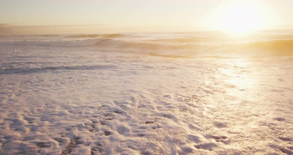 Sunset and sea with waves and blue sky on empty sunny beach