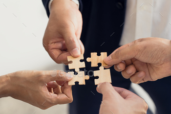 The concept of teamwork and partnership. Businessman's hands putting together puzzle