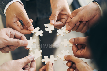 The concept of teamwork and partnership. Businessman's hands putting together puzzle