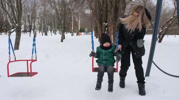 Cute Mother Puts Mittens on Her Child