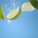 Super slow motion shot of lemons and limes falling into the water with a splash. Blue background. - VideoHive Item for Sale