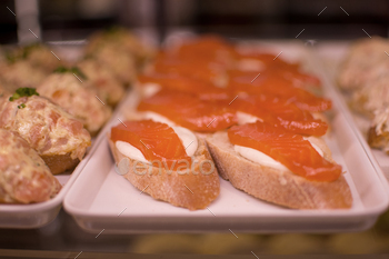 a tray of food with food on it including salmon and other food.