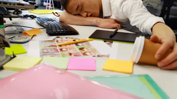 Male graphic designer sleeping at desk