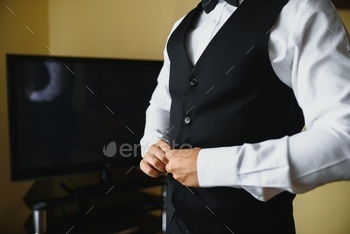 A man fastens buttons on his shirt