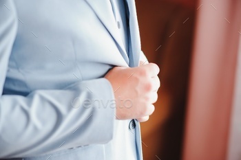 A man fastens buttons on his shirt