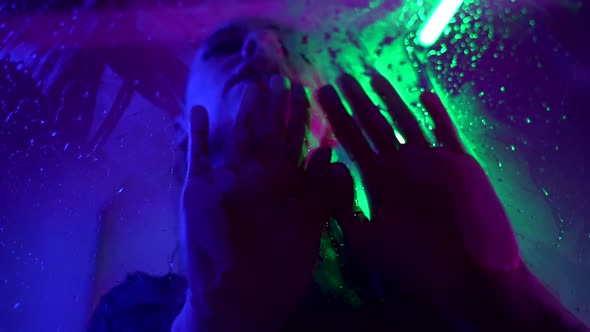 Depressed Woman Is Crying in Shower in Darkness Closeup Portrait Behind Wet Glass