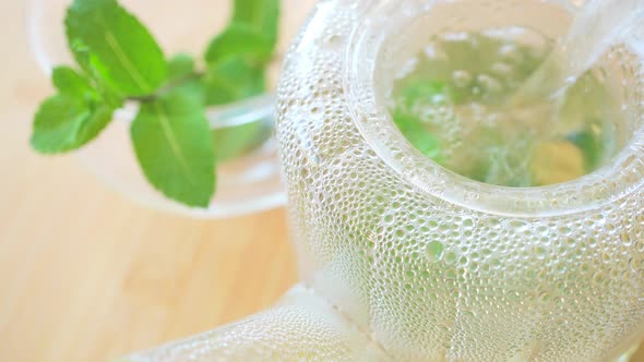 Pouring hot water to fresh mint tea