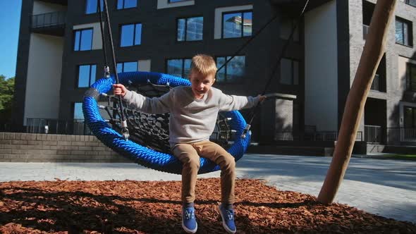 Child Boy Enjoy at Swing at Playground Near Home