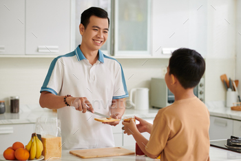 Son Helping Father to Make Sandwiches
