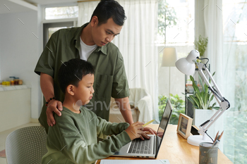 Father Helping Preteen Son with Programming