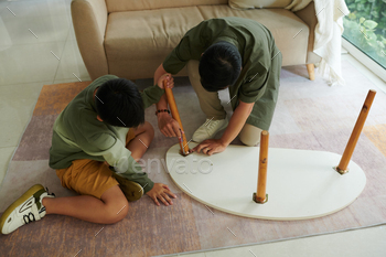 Son Helping Father to Assemble Table