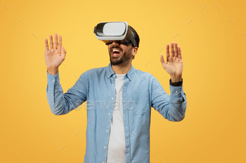 Man with virtual reality headset on yellow backdrop