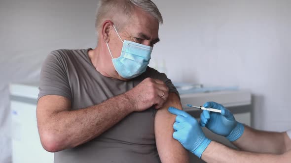 Elderly Man in Face Mask Getting Covid Vaccine