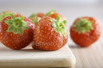 Ripe strawberries on wooden board