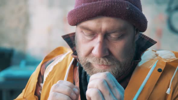 Close Up of a Tramp Trying to Warm Up His Hands