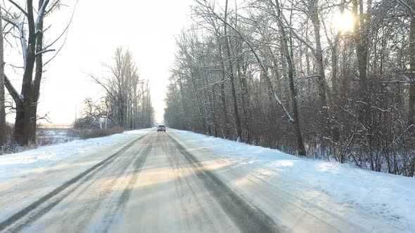 Following To White Car Riding Through Snow Covered Icy Road