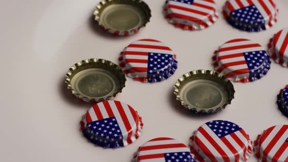 Rotating shot of bottle caps with the American flag printed on them