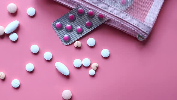 Top View of Colorful Pills Spilling on Pink Background 