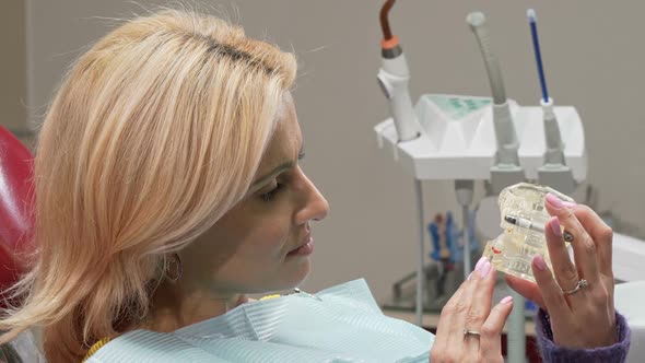 Mature Woman Smiling To the Camera, Holding Dental Mold at the Clinic