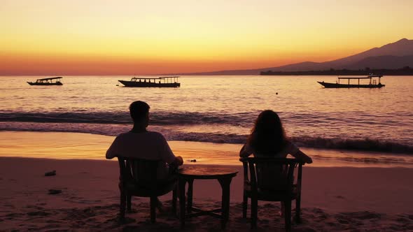 Teenage lovers engaged on tranquil tourist beach wildlife by shallow lagoon and white sandy backgrou