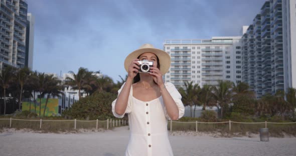 Smiling woman with a retro camera in Miami. Shot on Black Magic Cinema Camera