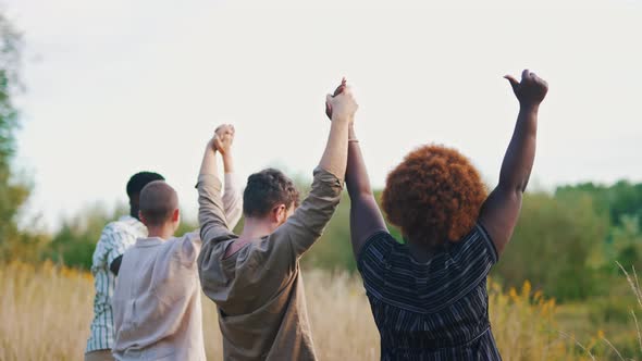 Mediumfull Shot of Multiethnic Friends with Their Hands Up