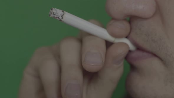 Cigarette in the Mouth of a Smoker. Close-up. Chroma Key. Green Background