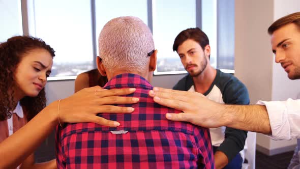 Creative business team consoling upset colleague