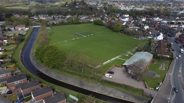 Aerial drone shot over rural suburb football pitch in housing estate, England