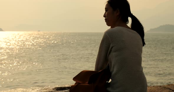 Woman looking at the sea under sunset