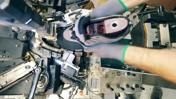 Shoe Manufacturing Worker Using a Shoe Making Machine at Factory Facility